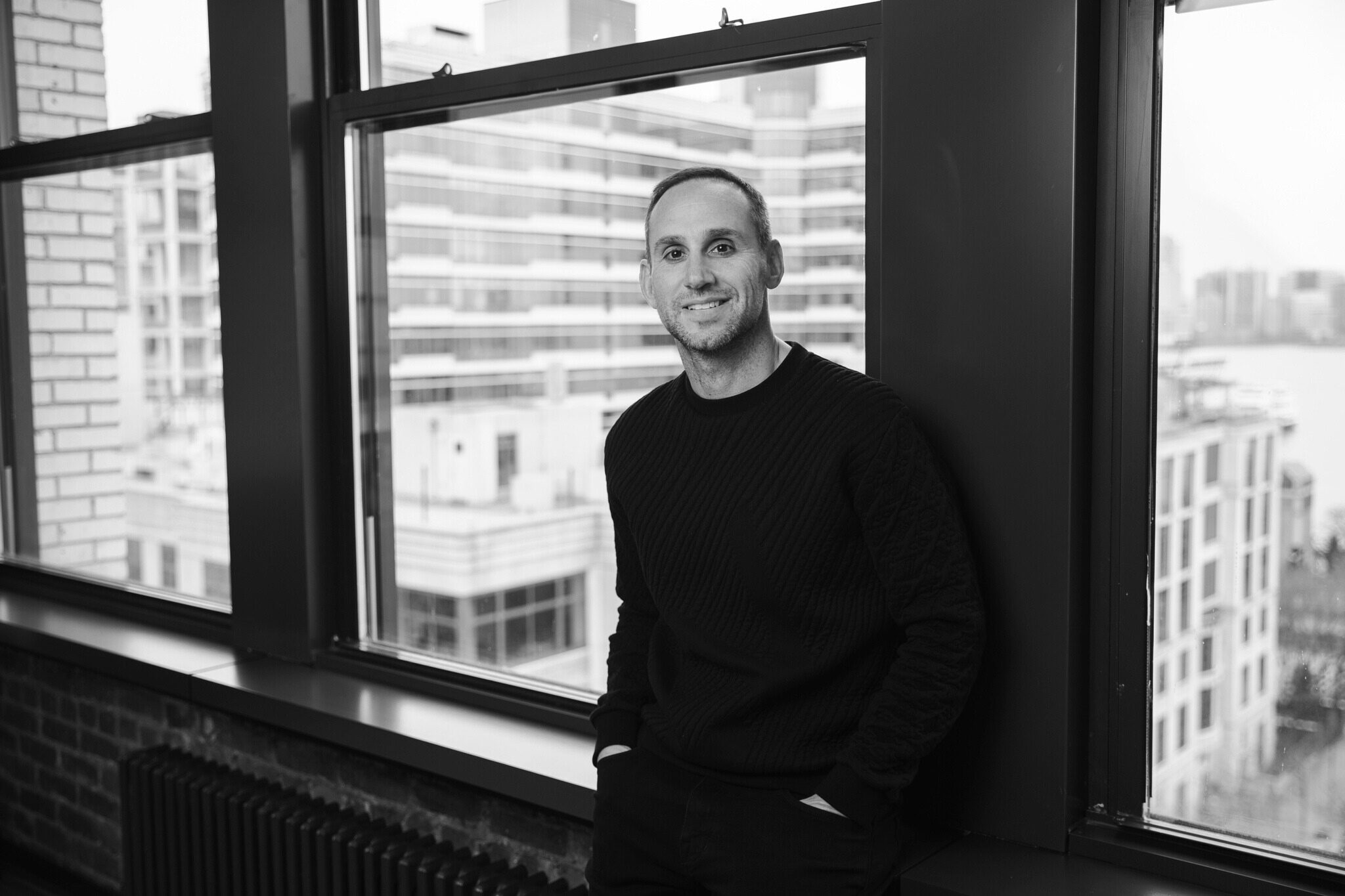 Michael Rubin, Founder & CEO of Fanatics, wearing a black shirt in front of a window